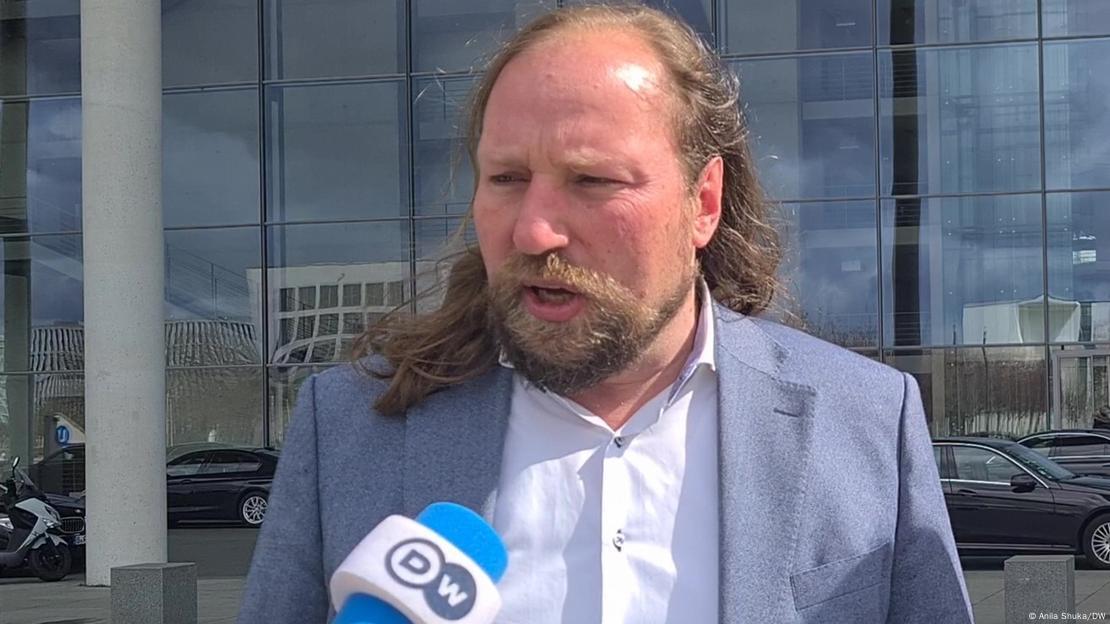 Der Grüne  Anton Hofreitersteht vor einem Bundestagsgebäude und gibt der DW ein Interview