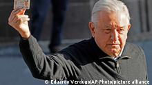 Mexico´s President Andres Manuel López Obrador shows his identification card after voting in a national referendum on whether he should end his six-year term barely midway through or continue to the end, outside his polling station in Mexico City, Sunday, April 10, 2022. (AP Photo/Eduardo Verdugo)