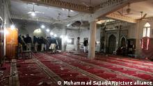Police officers and investigators examine the site of suicide bombing inside a Kusha Kisaldar Shiite Mosque, in Peshawar, Pakistan, Friday, March 4, 2022. In northwest Pakistan the remains of an IS suicide bomber are still visible on the once ornate walls of a mosque where last month more than 63 worshippers died as they knelt in prayer. The bomber, an Afghan identified by IS as Julaybib al-Kabuli, was from the capital Kabul. (AP Photo/Muhammad Sajjad)