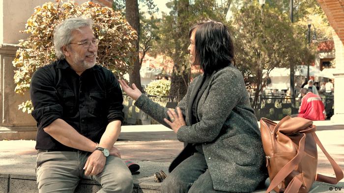 Journalists Can Dündar and Anabel Hernández sitting on a bench and discussing