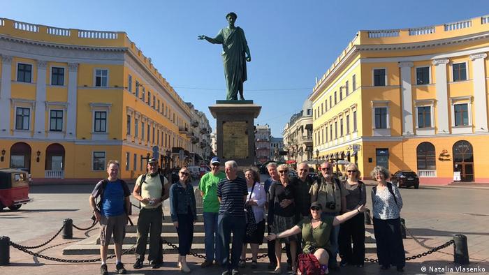 Eine Gruppe Touristen steht vor einem Denkmal in Odessa, Ukraine