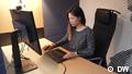 Eine asiatisch aussehende Frau sitzt vor einem Computer. (DW)
