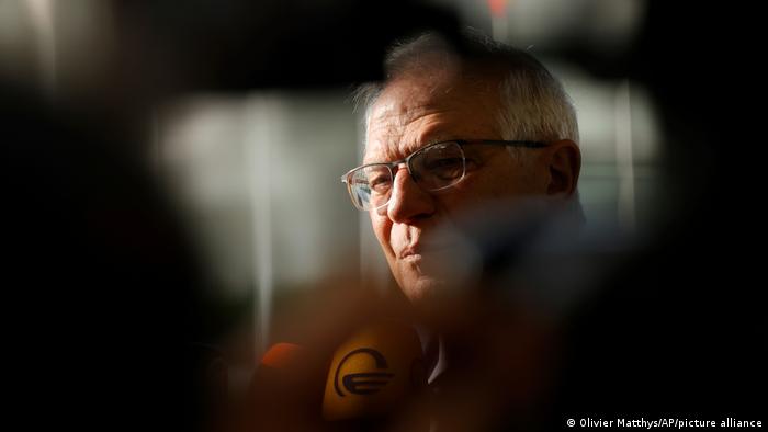 Josep Borrell pictured through a throng of journalists while arriving for a foreign ministers' meeting in Luxembourg