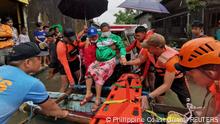 Rescue personnel assist a woman onto a raft amidst flooding, after the tropical storm Megi hit, in Leyte Province, Philippines April 10, 2022. Picture taken April 10, 2022. Philippine Coast Guard/Handout via REUTERS THIS IMAGE HAS BEEN SUPPLIED BY A THIRD PARTY. MANDATORY CREDIT. NO RESALES. NO ARCHIVES TPX IMAGES OF THE DAY 