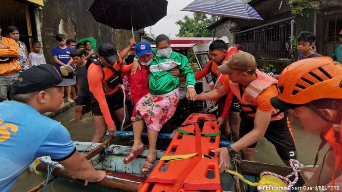 Спасатели эвакуируют женщину из затопленной деревни на Филиппинах