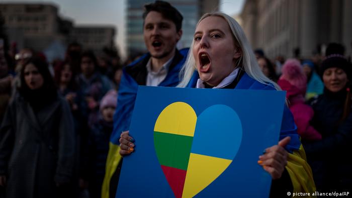 A woman holds a placard expressing solidarity with Ukraine
