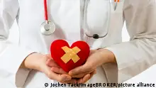 Medizinerin hält ein rotes Herz mit Pflaster in den Händen, Symbolbild Herzinfarkt || Modellfreigabe vorhanden
