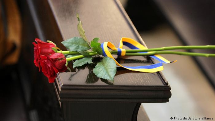 Розы и лента в цветах украинского флага в церкви