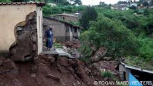A woman stands at her front door after heavy rains caused flood damage in KwaNdengezi, Durban, South Africa