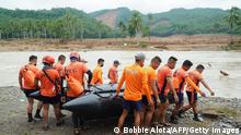 Rescuers carry an inflatable boat towards a river as they attempt to reach the landslide-hit village of Kantagnos in Baybay town, Leyte province on April 13, 2022, following heavy rains brought about by tropical storm Megi. (Photo by BOBBIE ALOTA / AFP) (Photo by BOBBIE ALOTA/AFP via Getty Images)