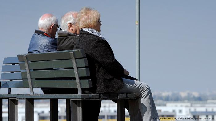 Three pensioners sitting on a bench