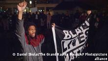 Protesters carrying a Black Lives Matter flag march inside a fountain at Veterans Memorial Park following a march from the Grand Rapids Police Department. The protest was held in response to videos of the shooting of Patrick Lyoya, by a Grand Rapids police officer from April 4, being released to the public on Wednesday, April 13, 2020, in Grand Rapids, Mich. (Daniel Shular/The Grand Rapids Press via AP)