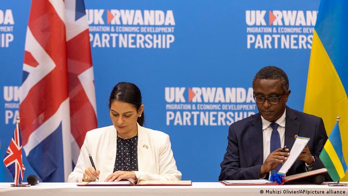 Britain's Home Secretary Priti Patel, left, and Rwanda's Minister of Foreign Affairs Vincent Biruta, right, sign what the two countries called an economic development partnership.