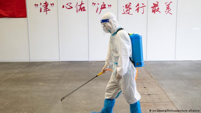 A staff member disinfects an area in a makeshift hospital in Shanghai