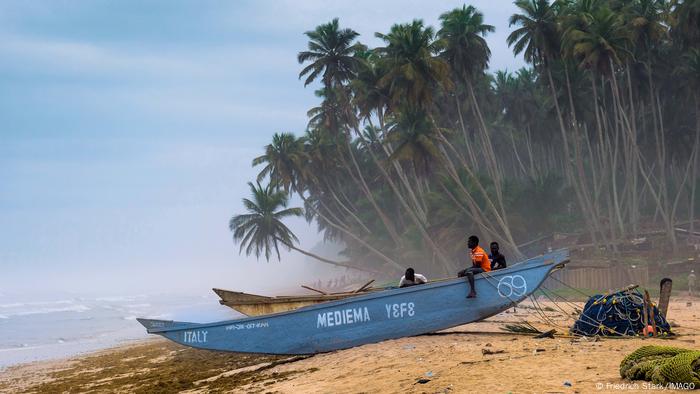 Fishermen on a boat at a landing beach.