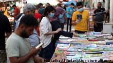 BAGHDAD, IRAQ - SEPTEMBER 25: People look at books and journals at historical Mutanabbi Street, favorite place for book lovers in Baghdad, as it is reopened after it was closed due to coronavirus (Covid-19) pandemic in Baghdad, Iraq on September 25, 2020. Murtadha Al Sudani / Anadolu Agency