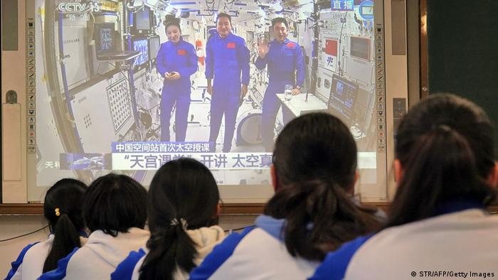 Students watch a live image of a lesson by Chinese astronauts from China's Tiangong space station. (Photo by STR/AFP via Getty Images)