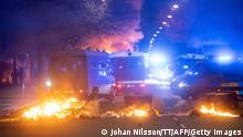 This photograph taken in Malmo late April 16, 2022 shows police trucks blocking a street next to burning garbage cans. - The unrest in Malmo has continued after the leader of the Danish right-wing extremist party Tight Course, held a demonstration on April 16, 2022 at Skanegarden near the Oresund Bridge. - Sweden OUT (Photo by Johan NILSSON / TT NEWS AGENCY / AFP) / Sweden OUT (Photo by JOHAN NILSSON/TT NEWS AGENCY/AFP via Getty Images)