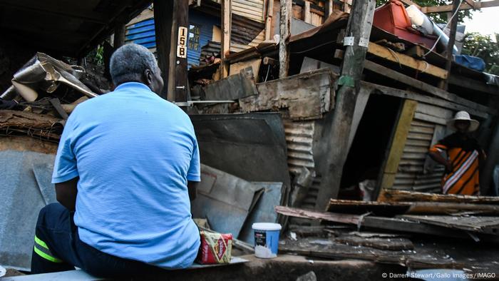 Ein Mann sitzt vor den Trümmern eines Hauses nach Unwetter in Durban, Südafrika