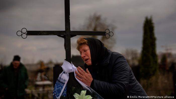 Женщина у могилы в Буче, 16 апреля