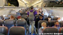 (FILES) In this file photo taken on May 03, 2020 passengers, almost all wearing facemasks, board an American Airlines flight to Charlotte, in New York City. - A federal judge on April 18, 2022 struck down the Covid-19 mask mandate for public transportation imposed by the US Centers for Disease Control and Prevention (CDC). (Photo by Eleonore SENS / AFP)