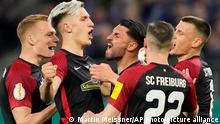 Freiburg's Noah Weisshaupt, center, celebrates with his teammates after scoring the third goal for his team with penalty against Hamburger during the German Cup, semifinal soccer match between Hamburger SV and SC Freiburg in Hamburg, Germany, Tuesday, April 19, 2022. (AP Photo/Martin Meissner)
