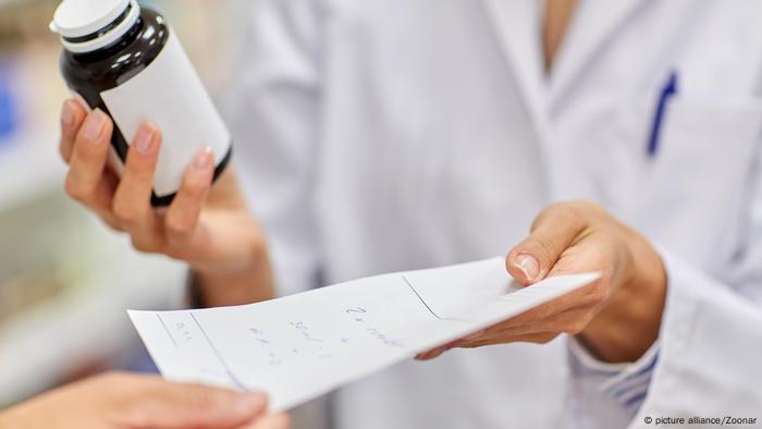 Person handing someone a prescription for medication