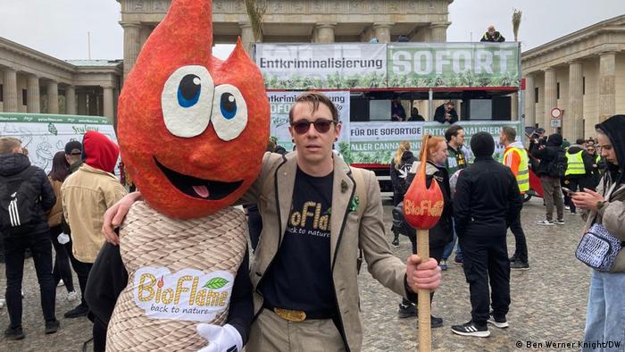 Code 420 Demonstration in Berlin, a person with his arm around the shoulder of a person dressed as a mascot