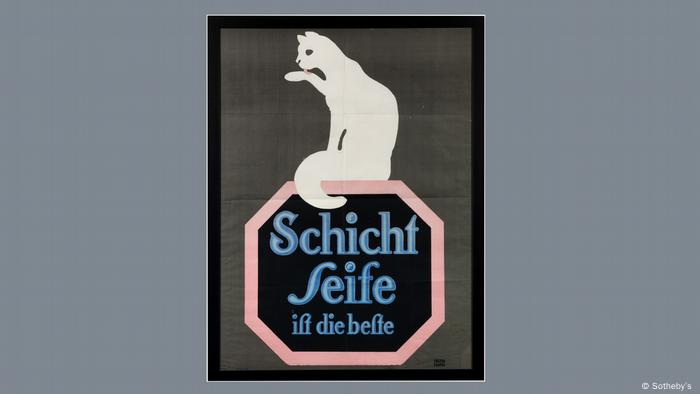 A white cat licks its paw on an advertising poster