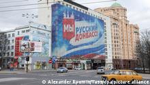  ***Achtung, dieses Bild stammt von der staatlichen russischen Bildagentur TASS*** DONETSK, UKRAINE - FEBRUARY 21, 2022: A poster reading We are Russian Donbass and bearing a Russian flag is pictured at a building. Denis Pushilin, head of the Donetsk People's Republic, asks Russian President Vladimir Putin to recognize independence of the Donetsk People's Republic. As tension escalated in east Ukraine on 18 February, 2022, the Donetsk People's Republic announced a mass evacuation of civilians to Russia. On 19 February 2022, it announced general mobilisation. Alexander Ryumin/TASS