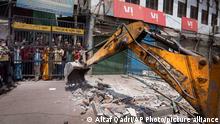 A bulldozer razes structures in the area that saw communal violence during a Hindu religious procession on Saturday, in New Delhi's northwest Jahangirpuri neighborhood, India, Wednesday, April 20, 2022. Authorities riding bulldozers razed a number of Muslim-owned shops in New Delhi before India's Supreme Court halted the demolitions Wednesday, days after communal violence shook the capital and saw dozens arrested. (AP Photo/Altaf Qadri)