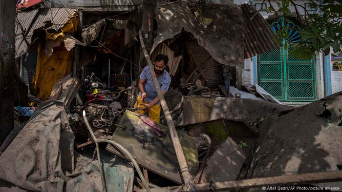 A shop owner weeds through the rubble of his shop after it was razed by bulldozers in New Delhi