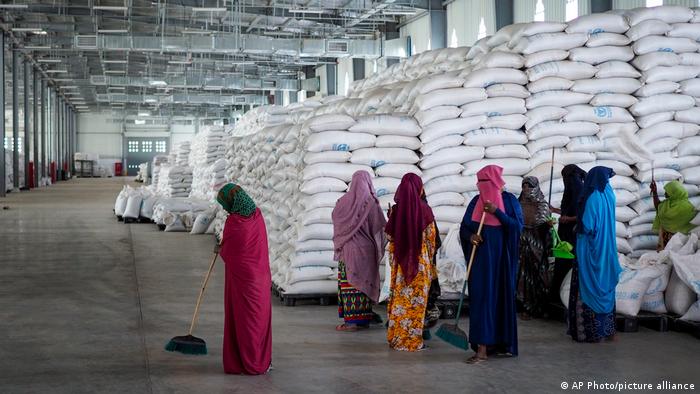 Workers clean the floor as sacks of food sit in warehouses in Ethiopia.