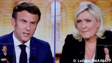 A picture shows screens displaying a live televised between French President and La Republique en Marche (LREM) party candidate for re-election Emmanuel Macron (L) and French far-right party Rassemblement National (RN) presidential candidate Marine Le Pen (R), broadcasted om French TV channels TF1 and France 2, in a viewing room at the studios hosting the debate in Saint-Denis, north of Paris, ahead of the second round of France's presidential election. - French voters head to the polls for a run-off vote between Macron and Le Pen on April 24, 2022. (Photo by Ludovic MARIN / AFP)