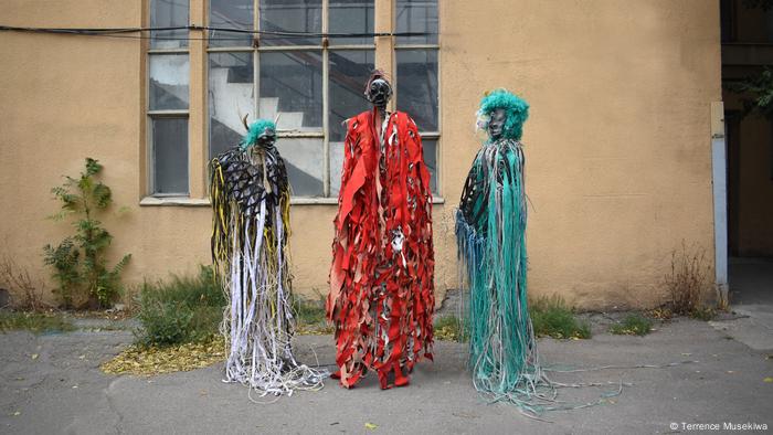 Three colorful human-like standing sculptures