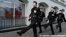 Schüler und Schülerinnen marschieren mit Gewehren, anlässlich einer langjährigen Tradition auf der Krim, zum Denkmal für die Verteidiger von Sewastopol. In dem Fenster des Gebäudes ist ein «Z»-Symbol mit der Aufschrift «Wir lassen unsere Leute nicht im Stich» angebracht. +++ dpa-Bildfunk +++