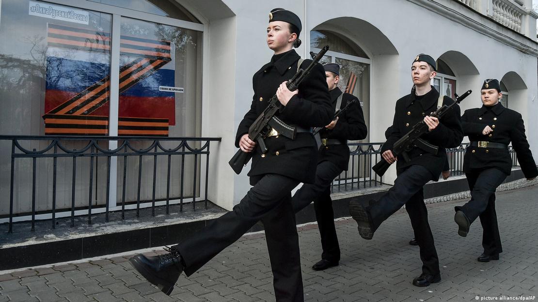 Ученици с пушки маршируват под знака "Z" 