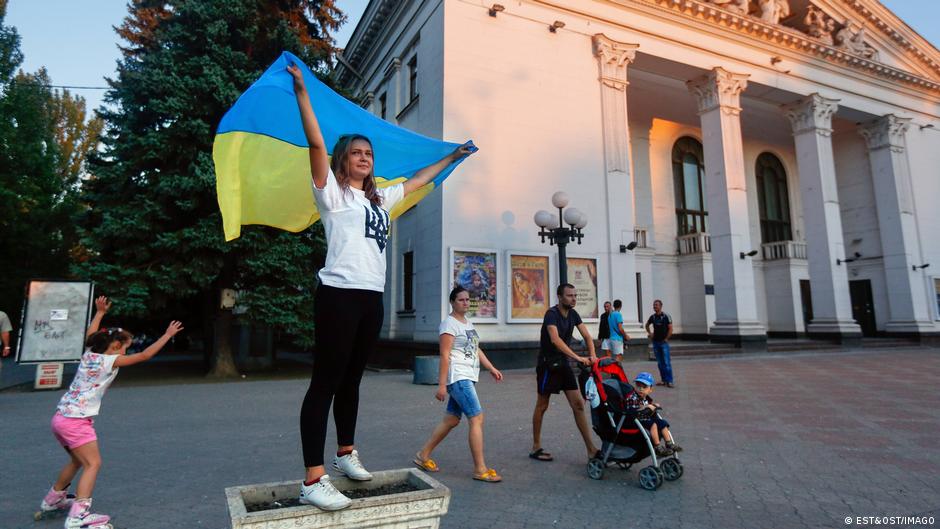 Ukrainian volunteers and activists take part in a rally in Mariupol, waving the Ukrainian flag