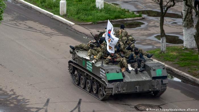 Separatistas prorrusos armados, sentados encima de un tanque con su bandera, en una calle de Sloviansk. 