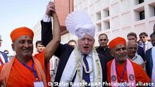 Britain's Prime Minister Boris Johnson, center, wears a turban on his head at the Gujurat Biotechnology University, in Gandhinagar, part of his two-day trip to India, Thursday, April 21, 2022. (Stefan Rousseau/Pool Photo via AP)
