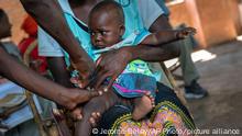 In this photo taken Wednesday, Dec. 11, 2019, health officials vaccine residents of the Malawi village of Tomali, where young children become test subjects for the world's first vaccine against malaria. Babies in three African nations are getting the first and only vaccine for malaria in a pilot program. World health officials want to see how well the vaccine works in Malawi, Ghana and Kenya before recommending its wider use. (AP Photo/Jerome Delay)