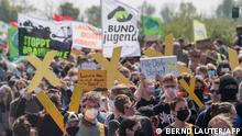 People take part in a protest against the destruction of a village for the expansion of the Garzweiler lignite open cast mine near Luetzerath, western Germany, on April 23, 2022. - German energy provider RWE is planning to entirely demolish houses in the village of Luetzerath for coal mining. (Photo by Bernd Lauter / AFP)
