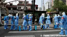 Workers in protective suits prepare to disinfect a residential compound in Huangpu district, following the coronavirus disease (COVID-19) outbreak in Shanghai, China April 20, 2022. China Daily via REUTERS ATTENTION EDITORS - THIS IMAGE WAS PROVIDED BY A THIRD PARTY. CHINA OUT. TPX IMAGES OF THE DAY 