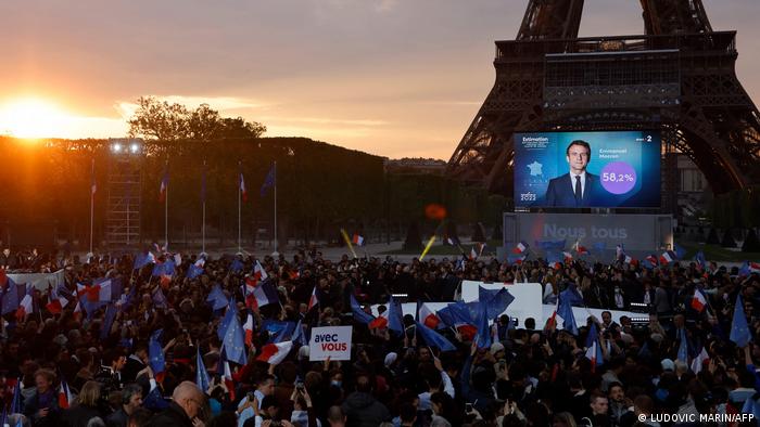 Macron's face on a screen at the foot of the Eiffel Tower