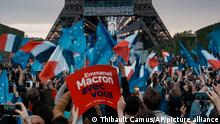 Supporters of French President Emmanuel Macron react as the first election projections are announced in Paris, France, Sunday, April 24, 2022. French polling agencies are projecting that centrist incumbent Emmanuel Macron will win France's presidential runoff Sunday, beating far right rival Marine Le Pen in a tight race that was clouded by the Ukraine war and saw a surge in support for extremist ideas. (AP Photo/Thibault Camus)