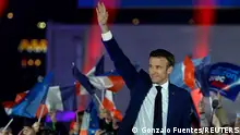 French President Emmanuel Macron waves on stage after being re-elected as president, following the results in the second round of the 2022 French presidential election, during his victory rally at the Champs de Mars in Paris, France, April 24, 2022. REUTERS/Gonzalo Fuentes