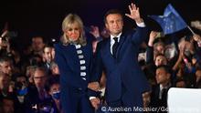 PARIS, FRANCE - APRIL 24: France's centrist incumbent president Emmanuel Macron and his wife Brigitte Macron acknowledge voters in front of the Eiffel Tower after after giving a speech after beating his far-right rival Marine Le Pen for a second five-year term as president with 58,8% votes on April 24, 2022 in Paris, France. Emmanuel Macron and Marine Le Pen both qualified on Sunday April 10th for France's 2022 presidential election second round held today, on April 24. This is the second consecutive time the two candidates face-off in the final round of elections. (Photo by Aurelien Meunier/Getty Images)