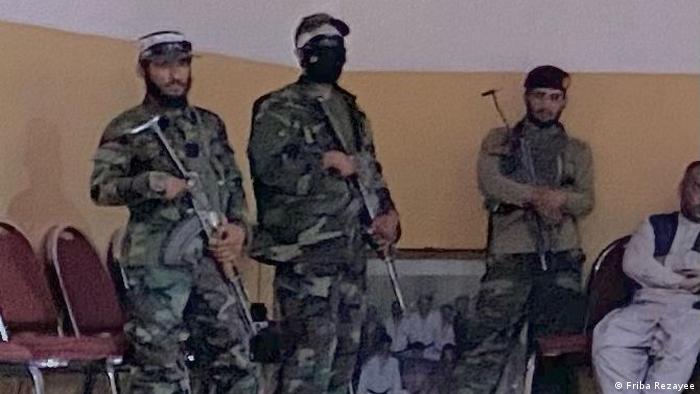 Armed Taliban soldiers patrol the training room of the judo team