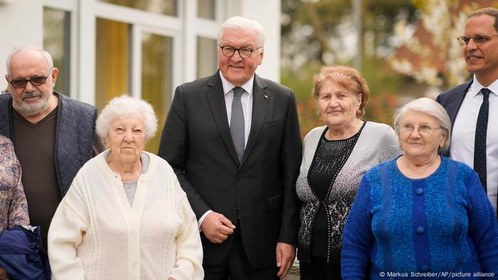 German President Frank-Walter Steinmeier stands alongside Holocaust survivors who fled Russia's invasion of Ukraine