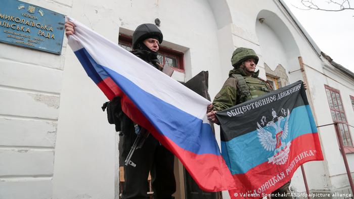 Nikolayevka | DVR-Soldaten posieren mit russischen und DVR-Flaggen im Dorf Nikolajewka